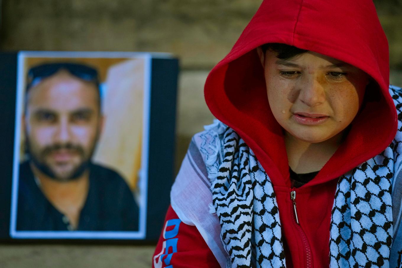 En pojke gråter intill ett porträtt på videojournalisten Issam Abdallah som dödades den 13 oktober. Foto: Bilal Hussein/AP/TT