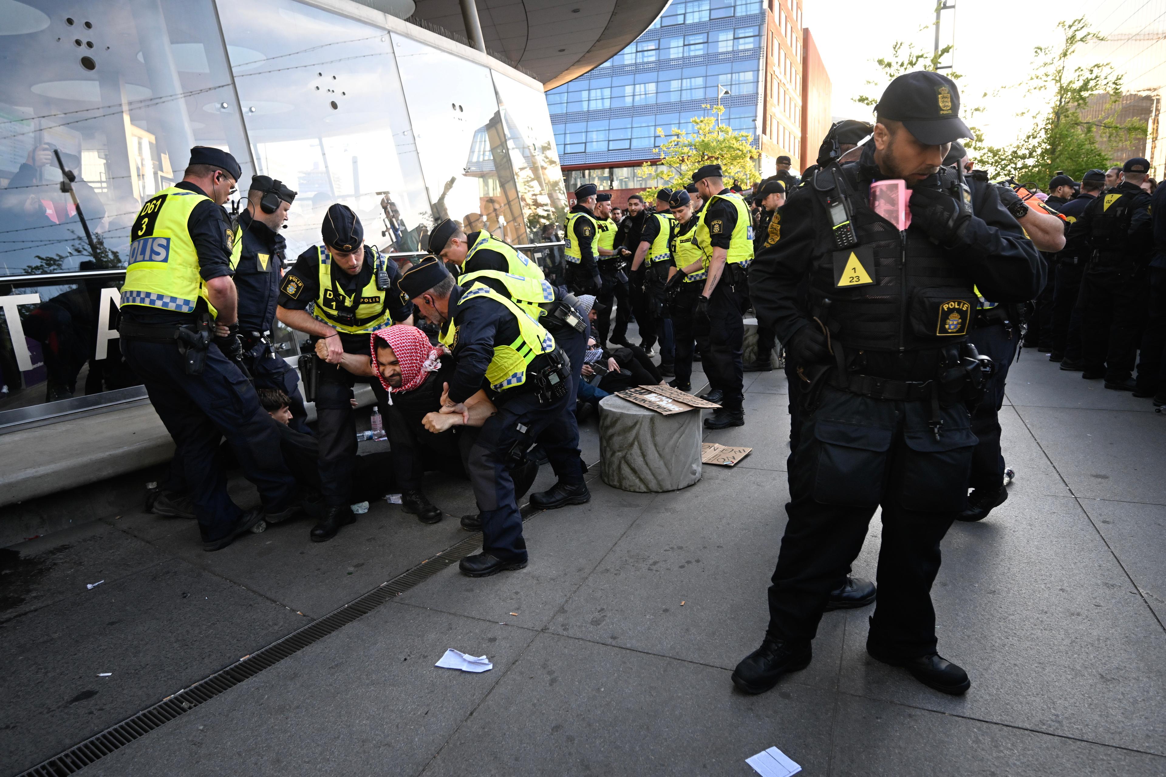 Demonstranter fick tas omhand av polis utanför Malmö arena i samband med att publiken släpptes in på arenan inför Eurovision Song Contest-finalen. Foto: Johan Nilsson/TT