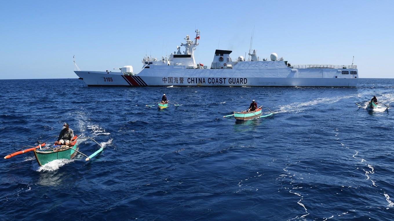 Filippinska fiskare och ett kinesiskt kustbevakningsfartyg i närheten av Scarborough Shoal i det omtvistade Sydkinesiska havet. Foto: Ted Aljibe/AFP via Getty Images