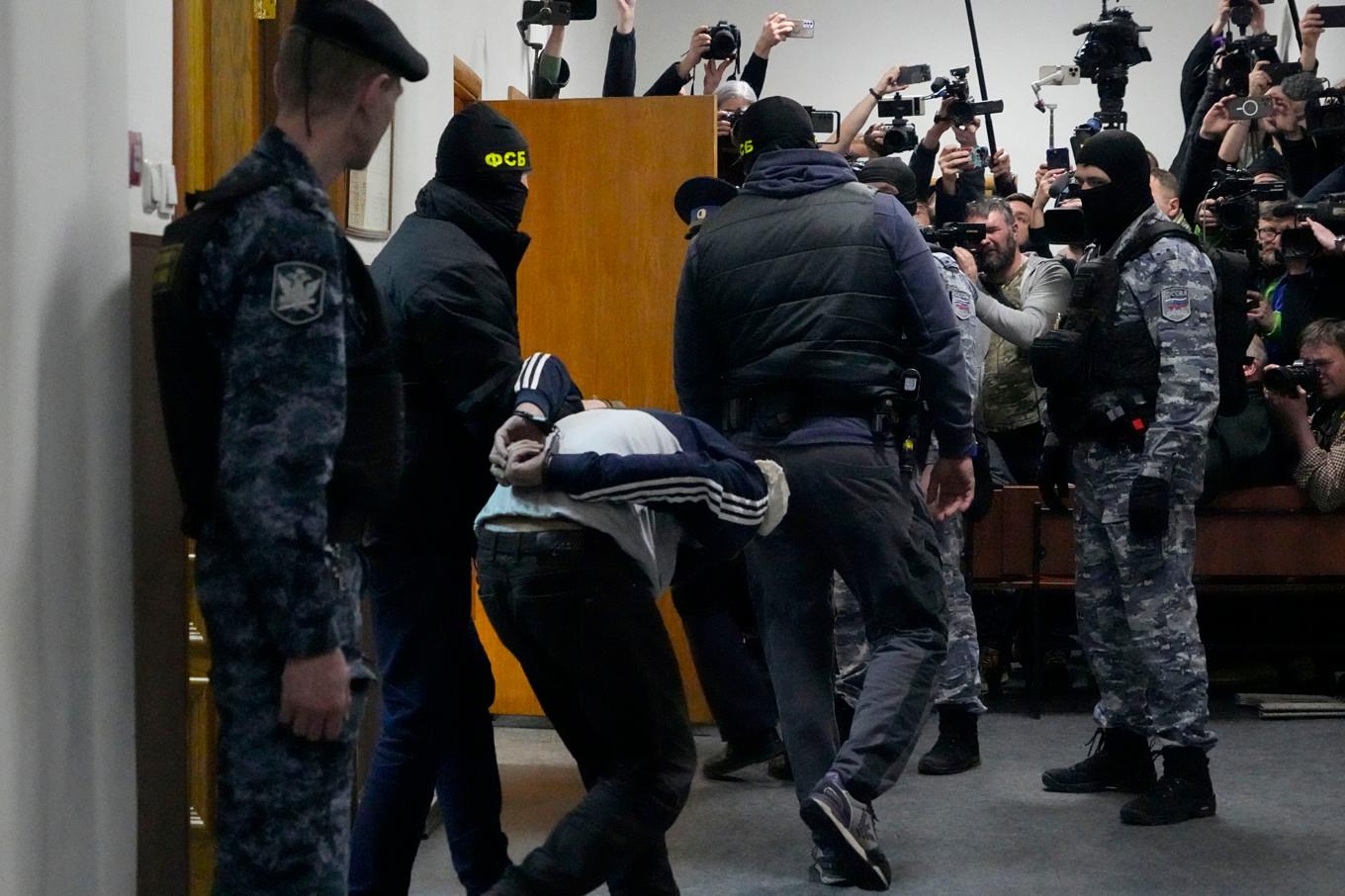 En av de misstänkta förs in i rättssalen i domstolen i Moskva på söndagskvällen. Foto: Alexander Zemlianichenko/AP/TT