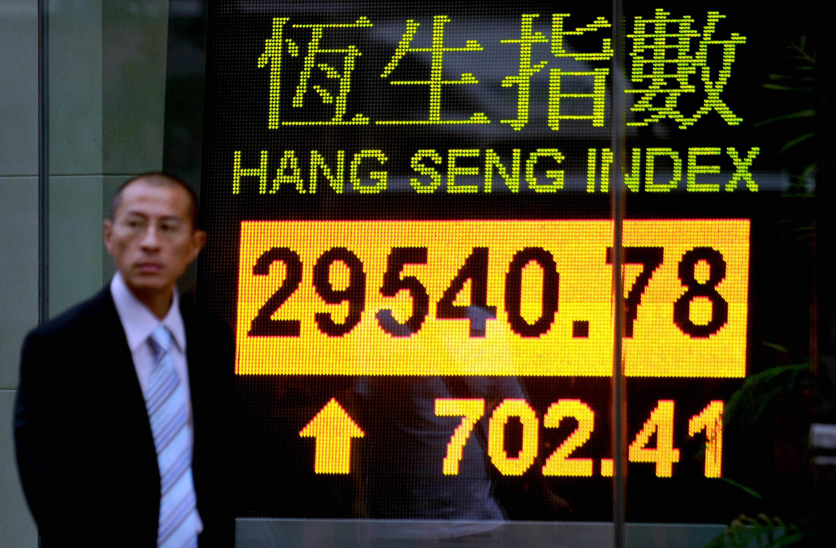En förbipasserande vid en tavla för Hang Seng-indexet i Hongkong. Foto: Philippe Lopez/AFP via Getty Images