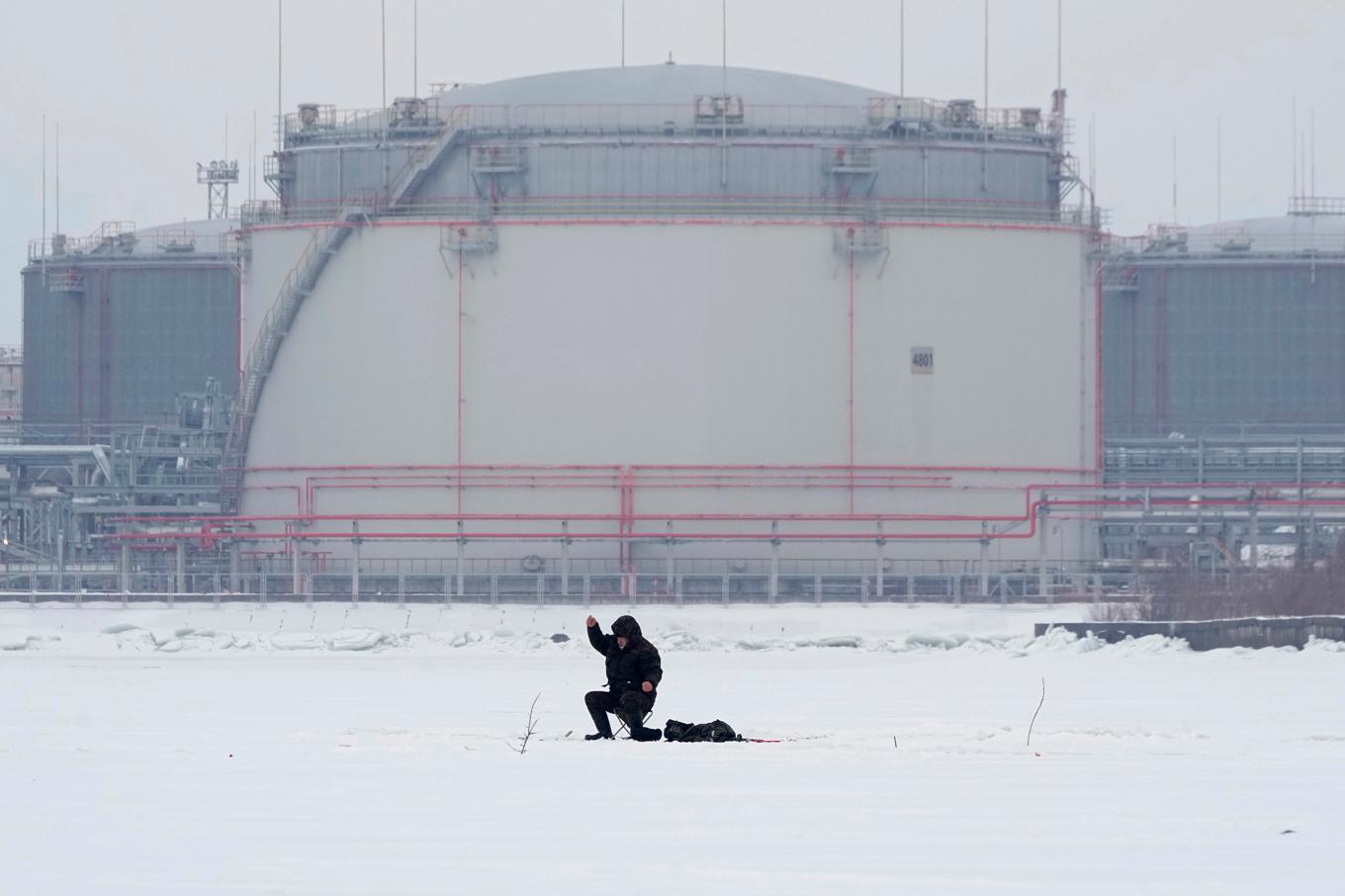 En ensam fiskare framför en oljecistern utanför S:t Petersburgs hamn. Arkivbild. Foto: Dmitrij Lovetskij/AP/TT