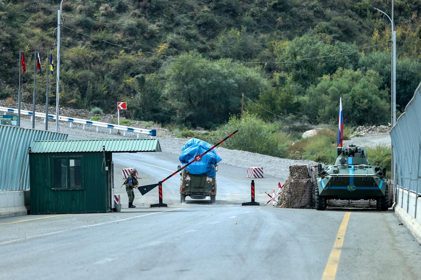 En man kör förbi ryska soldater i området vid Latjin-korridoren, som förbinder bergsregionen Nagorno-Karabach med Azerbajdzjan. Arkivbild. Foto: Aziz Karimov/AP/TT