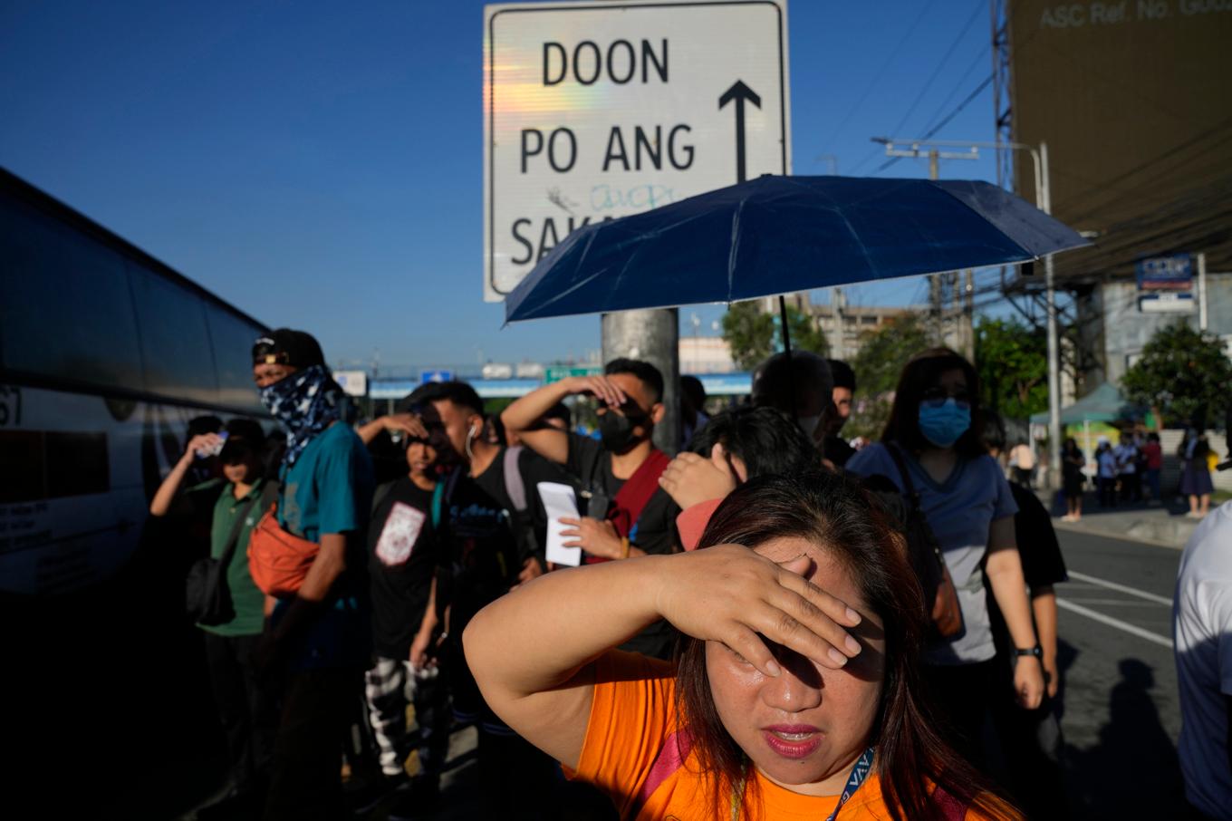 Pendlare försöker undvika solen under värmeböljan i filippinska Quezon City tidigare i april. Foto: Aaron Favila/AP/TT