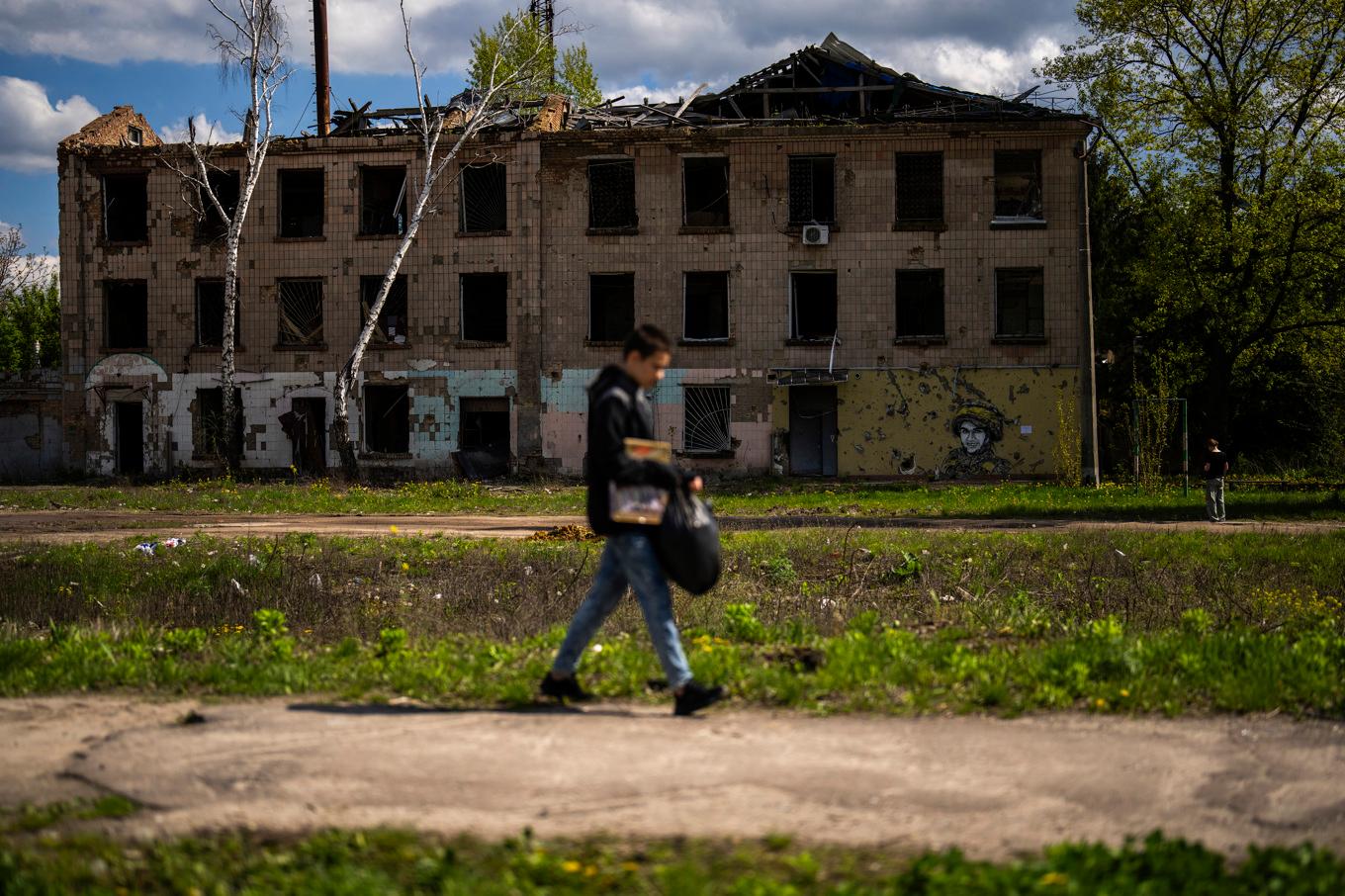 En ung man går förbi en delvis förstörd byggnad i Borodjanka norr om Ukrainas huvudstad Kiev. Bild från i lördags. Foto: Francisco Seco/AP/TT