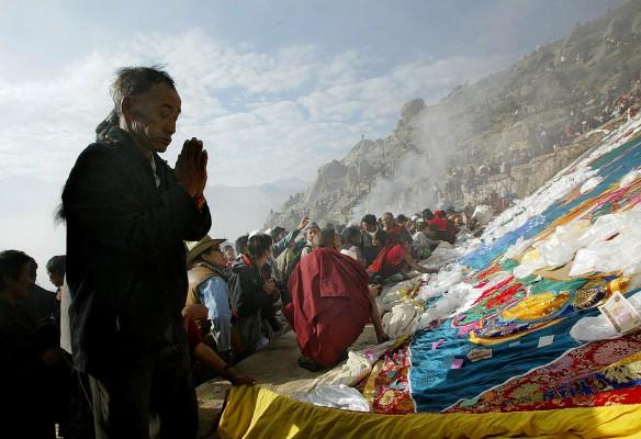 En man ber vid den enorma Thangkan vid Drepungklostret i Lhasa under den traditionella yoghurtfestivalen. (Foto: AFP / Frederic J. Brown)
