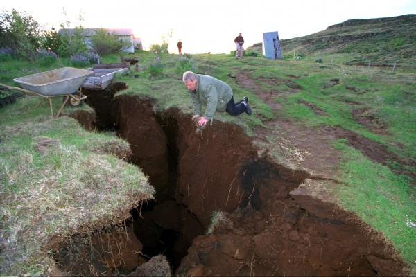 Så här såg det ut i juni 2000 efter en jordbävning på Island. Gretir Hjartarson ser ner i en tio meter djup och 150 meter lång spricka i närheten av sitt hus, 50 km öster om Reykjavik.