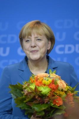 Den tyska kanslern och Kristdemokraternas kanslerkandidat Angela Merkel fick blommor efter att det första valresultatet rapporterades in, den 22 september 2013, valdagen. (Foto: Johannes Eisele / AFP) 