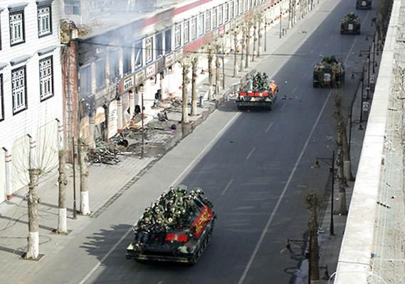 Kinesiska soldater i militärfordon patrullerar gatorna i Lhasa den 16 mars. (Foto: AFP/STR)
