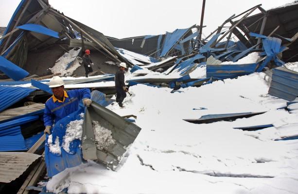 En brokonstruktion som kollapsat under en snöstorm i Zhengzhou, Henan provinsen. Minst 38 personer har dött de sista dagarna under de värsta snöstormarna som drabbat norra Kina på tiotals år. (Foto: China Out/AFP)

