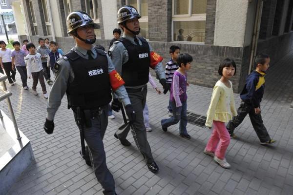 Kinesiska säkerhetsvakter i skottsäkra västar patrullerar i Peking efter blodbad på kinesiska skolor. (Foto: AFP)