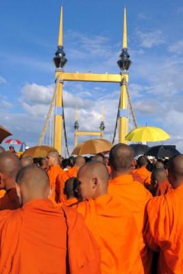 Tornen framför munkarna tillhör en bro i Phnon Penh i Kambodja. Där blev cirka 350 personer ihjältrampade under den pågående vattenfestivalen. De buddhistiska munkarna kom för att be för offren. (Foto: Nam Hoang Dinh / AFP)