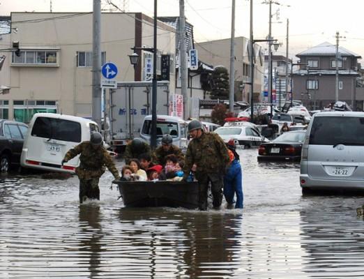 Soldater hjälper några invånare i Tagajo, Miyagi, med en båt i den översvämmade staden. (Foto: Jiji Press/ AFP)