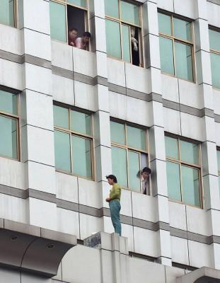 En kvinna hotade med att hoppa från en byggnad i Hefei, Anhuiprovinsen, i juli förra året. Hon hoppade aldrig, men fler än 250 000 kineser tar varje år sitt liv. (Foto: AFP)