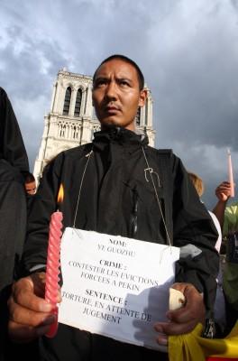 En protesterande grupp människor vilka kallar sig för "medborgare som reagerar", under en demonstration famför Notre-Dame katedralen i Paris, den 7 augusti 2008. Protesten var emot de olympiska spelen i Peking och för att väcka medvetenhet om effekterna av spelet, samt medvetenhet om invasionen av Tibet, arresterandet av dissidenter, internetblockader och felaktiga frihetsberövanden. (Foto: AFP/ Pierre Verdy)
