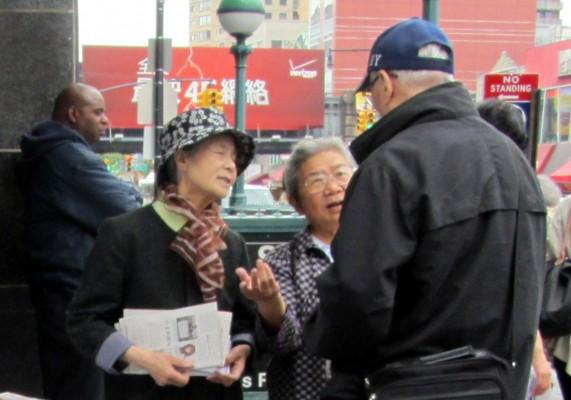 Två volontärer från Tuidangcentret i Flushing, New York, pratar om det kinesiska kommunistpartiet med en kinesisk man. (Foto: Susanne Willgren, Epoch Times Sverige)
