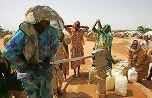 Sudanesiska kvinnor pumpar vatten ur en brunn i ett läger för inhemska flyktingar nära gränsen mellan Sudan och Chad. (Foto: Cris Bouroncle/AFP/Getty Images)

