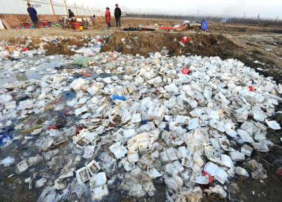 Människor vid en fyllnadstipp som är full av engångslunchlådor utanför ett bygge i Hefei, provinshuvudstad i Anhui. 40 000 härad och nästan 600 000 byar i Kina har ingen infrastruktur för miljöskydd, samtidigt som de producerar 280 miljoner ton avfall om året. (Getty Images)
