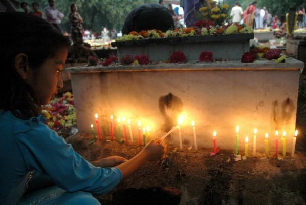 En flicka i Hyderabad, Indien, tänder ljus vid en död släktings grav på Alla själars dag den 2 november. Kristna ber då för de bortgågnas själar som renas i skärselden innan de går upp till himlen. Bland vetenskapsmännen råder dock oenighet om själens existens. (Foto: Noam Seelam/AFP)