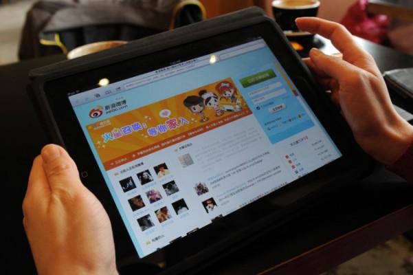 En kvinna tittar på den kinesiska sajten Weibo på ett café i Peking, 2 april 2012. Den kinesiska regimens senaste knep för att kontrollera internet är att gripa “bråkmakare” som lägger upp information om korruption på en tipssida. (Foto: Mark Ralston/AFP/Getty Images)