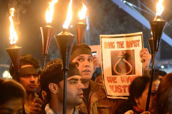 Indiska demonstranter håller upp facklor och plakat under en demonstration i New Delhi den 29 december 2012, efter att en student avlidit i den indiska huvudstaden som följd av en gruppvåldtäkt. En indisk domstol dömde på tisdagen fyra personer till skyldiga för våldtäkt och mord. (Foto:  Raveendran / AFP / Getty Images)