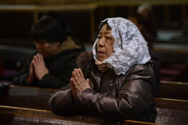 En kinesisk kvinna ber i en kyrka i Peking den 20 februari. Ett nyhetsteam från Sky News som undersöker en frihetsberövad pastor från en partiregistrerad kyrka i Henanprovinsen, attackerades fysiskt av en mobb som advokater sade var lejda av lokala tjänstemän. (Foto: Mark Ralston/AFP/Getty Images) 