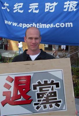 Deltagare  vid ett Epoch Times-evenemang för att sprida de Nio kommentarerna visar upp ett plakat där det står ”Gå ur kommunistpartiet!” (Foto: Epoch Times)