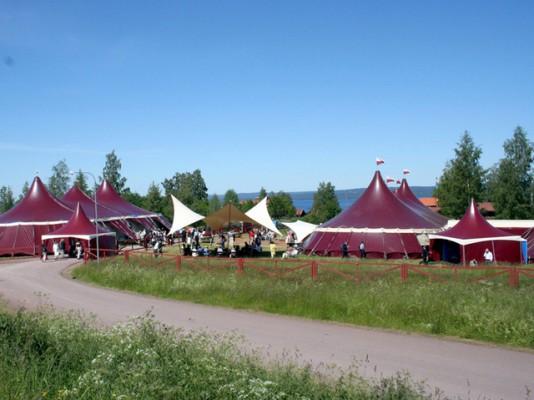 Som en forntida riddarborg inbäddad i sommargrönskan inhyser denna tältbyggnation Tällberg Forums aktiviteter. (Foto: Privat från svenska CH)
