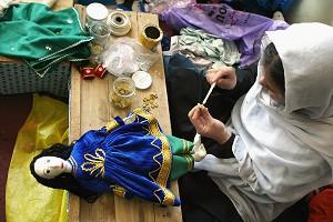 Berättigande av kvinnor: En afghansk kvinna syr en klänning till en docka på Kabuls dockfabrik. Fabriken är ett företag som drivs av kvinnor och de flesta anställda är änkor. (Foto: AFP/GettyImages)
