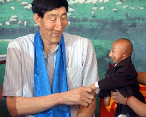 Världens längste man, Bao Xishun, skakar hand med världens kortaste, He Pingping. (Epoch Times)