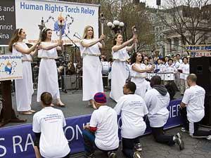 Fem facklor överräcks från löpare till kvinnor utklädda till grekiska gudinnor. Fackelstafetten för mänskliga rättigheter anlände till New York den 13 april. (Foto: Dayin Chen/Epoch Times)
