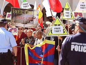 Polis eskorterar en tibetansk demonstrant genom en samling kinesiska supportrar vid den olympiska fackelstafetten i Canberra i Australien. (Mark Nolan/Getty Images)
