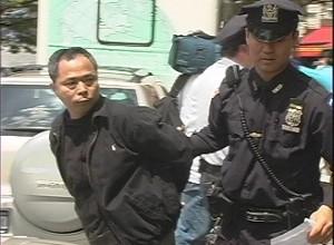 En polis i New York arresterar en misstänkt KKP-agent.  (Foto: Epoch Times)
