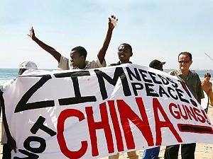 Medlemmar av och supporters till Kwazulu-Natals kristna råd och Diakonias kyrkoråd som den 19 april 2008 höll morgonbön under temat ”Hand i hand mot vapnen” på Durbans strand för att protestera mot Kinas export av vapen till det fattiga Zimbabwe. (Rajesh Jantilal/AFP/Getty Images)