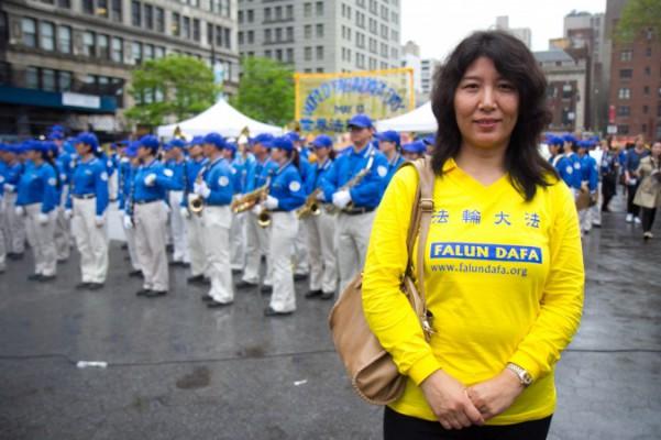 Shiping Lu poserar medan Divine Land Marching Band som utgörs av Falun Gong-utövare framträder på Union Square, New York, den 15 maj 2014 (Foto: Benjamin Chasteen/Epoch Times).
