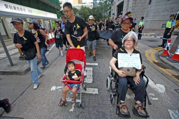 4 000 människor marscherade under söndagen till stöd för Occupy Central-rörelsen i Hongkong som kräver allmän rösträtt för stadsstaten. De höll långa, svarta banderoller och bar svarta tröjor med gula band. (Foto: Pan Zaishu/Epoch Times)