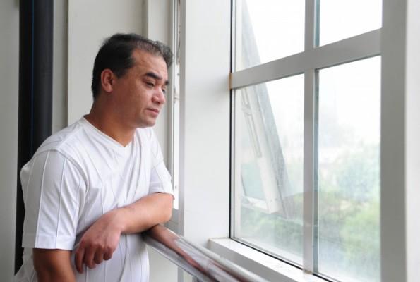 Universitetsläraren, bloggaren och uiguren Ilham Tohti ser ut genom klassrumsfönstret innan en föreläsning i Peking, den 12 juni 2010. (Frederic J. Brown/AFP/Getty Images)
