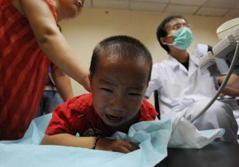 Ett barn som fått i sig förorenat mjölkpulver undersöks med ultraljud på ett sjukhus i Wuhan i Hebeiprovinsen den 17 september. (Kina: China photos/Getty Images)