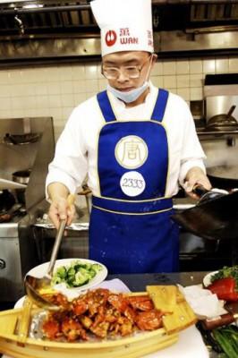Vinnaren Chen Yongming i avdelningen för Shandongkök förbereder rätten ’två drakar flytande på moln.’ (Foto: Bing Dai/Epoch Times)

