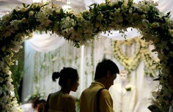 "Olämplig för den höga positionen, ovillig att ta en en lägre", är ett kinesiskt talesätt som kommit att passa in på många giftasmogna singlar i Kina. På bilden syns ett kärlekspar på en bröllopsmässa i Peking. (Foto: Getty Images)