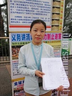 En volontär för centret ”Träd ur det kinesiska kommunistpartiet” i Hongkong visar upp för en reporter en namnlista på över tusen kinesiska turister. (Foto: Li Zhen/The Epoch Times)