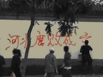 Gravida Zhao Chunhong målar slagord mot korruption på en vägg. (Foto: Epoch Times)
