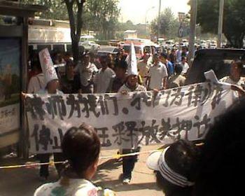 Demonstranter visar en banderoll med texten "Advokaterna brys sig om oss och vi bryr oss om dem. Stoppa förtrycket av advokater, släpp fängslade appellanter". (Foto: Epoch Times)
