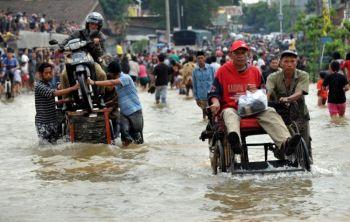 Människor vadar på en gata som är översvämmad av kraftiga regn i staden Tangerang i Banten provinsen den 26 oktober, dagen efter skalvet. (Foto: Adek Berry / AFP / Getty Images)
