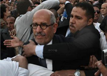 Egyptiske oppositionsledaren Mohamed ElBaradei leds i säkerhet den 19 mars när hundratals islamister kastade stenar och skor på honom när han skulle rösta i Kairo. (Foto: Mahmud Skinka/AFP/Getty Images)