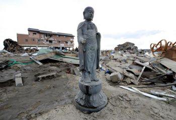 En Buddhastaty står upp bland spillrorna i ett område nära havet i Natori, Miyagi området i Japan. Området ödelades av tsunamin som följde efter jordbävningen i Japan den 14 mars 2011. (Toru Yamanaka/AFP/Getty Images) 
