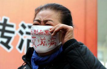 En kvinna som fick HIV av infekterat blod deltar i en demonstration på världsaidsdagen i Peking, 2009. (Foto: AFP/Getty Images)