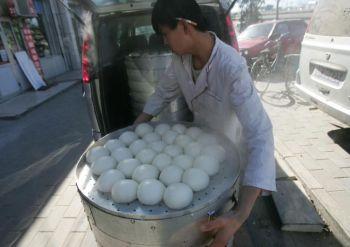 En man lastar in ”dumplings” (ångkokta kinesiska bullar med fyllning) i en lastbil i Peking i mars 2008. Nyligen stängdes Shanghai Shenglus fabrik för att man hittat kemikalier i företagets matbullar. (Foto: China Photos/Getty Images)
