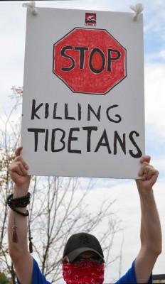 En demonstrant håller upp en skylt under den tibetanska protesten framför den kinesiska ambassaden i Washington DC den 13 juli. Protesten var riktad mot den kinesiska regeringens planerade firande av 60 års kinesiskt styre i Tibet, och organiserades av Students for a Free Tibet. (Foto: Hannah Hoffman/AFP/Getty Images)