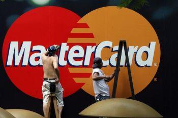 Arbetare rengör en reklamskylt för Mastercard i Kina. Kreditkortsskulder som inte betalats på sex månader eller mer har ökat kraftigt i landet sedan förra året. (Mike Clarke/AFP/Getty Images)